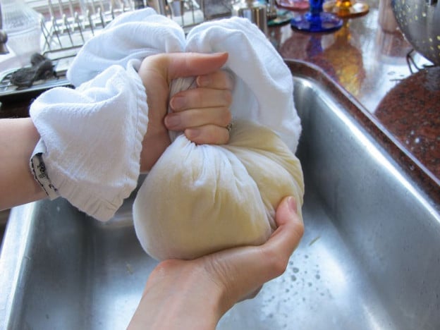 Squeezing out moisture from shredded potatoes.