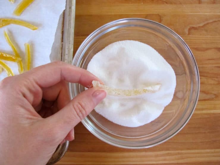 Rolling lemon peels in sugar.