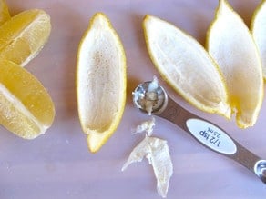 Scraping fibers from lemon peel.