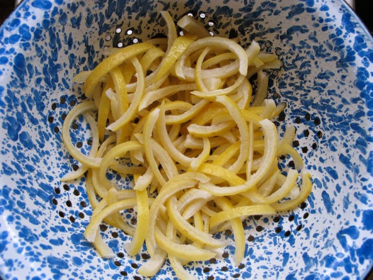 Boiled lemon peels in a colander.