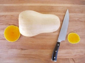 Slice the ends off a butternut squash.