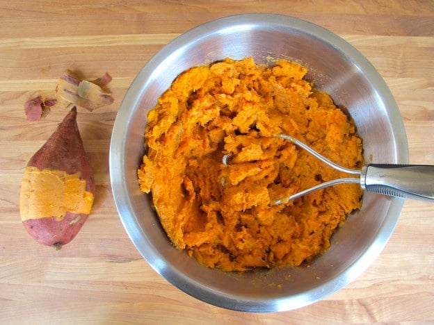 Mashed sweet potatoes in a mixing bowl.