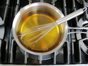 Dissolving sugar in apple cider in a saucepan.