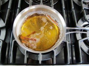 Simmering spices in apple cider in a saucepan.