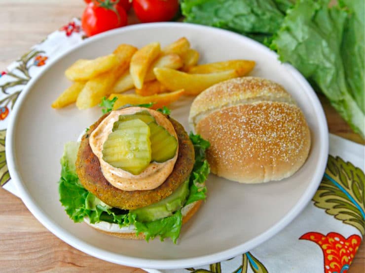 Black Eyed Pea Burgers with pickles and fires serve neatly n a white plate