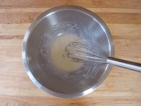 Whisking glaze in a small bowl.
