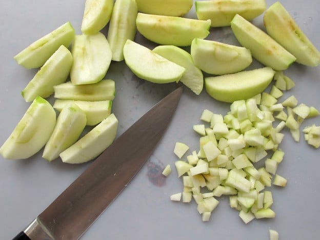 Finely diced apple on a cutting board.