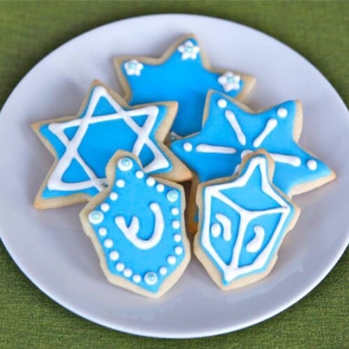Holiday sugar cookies with colorful icing and festive designs served on a white plate