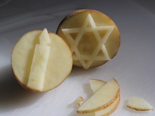 Potato stamps craved with star of David and candle.