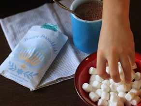 Adding marshmallows to hot cocoa.