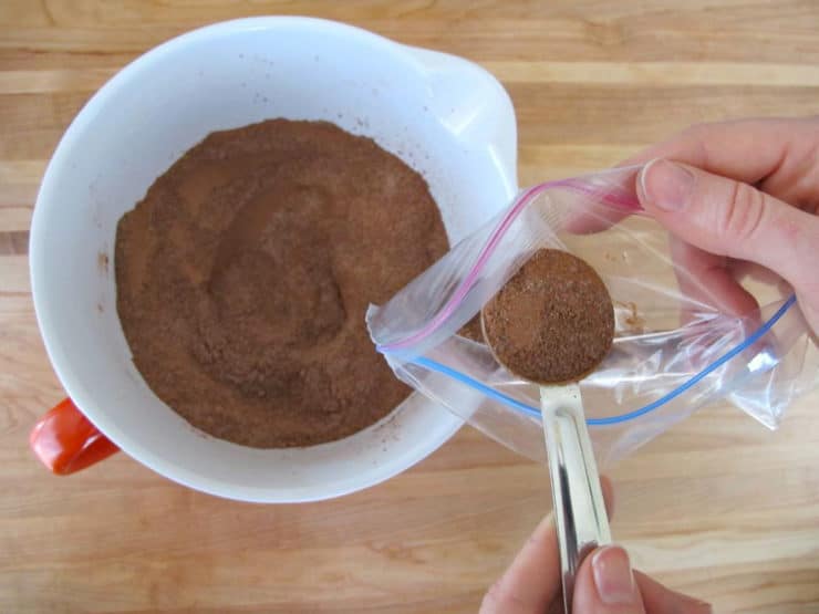 Measuring hot cocoa mix into a baggie.