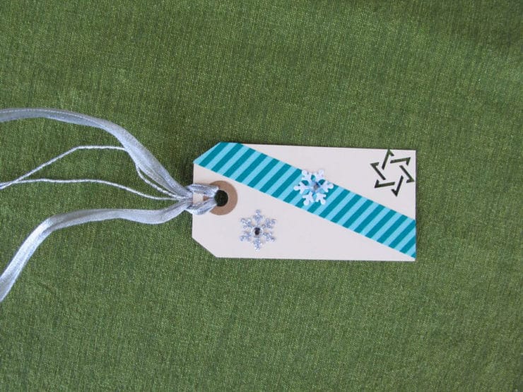 Paper gift tag with ribbon decorated with stickers. 