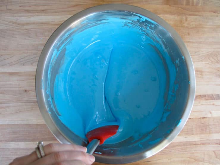 Stirring blue icing with spatula. - line in center of icing.