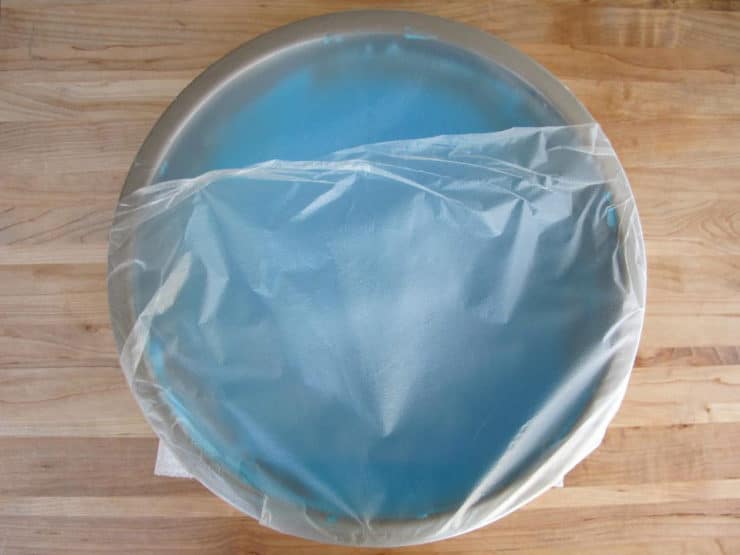 Bowl of icing covered with plastic wrap.