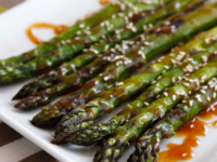 Roasted fresh asparagus spears coated in sesame seeds, sauce, and roasted to perfection