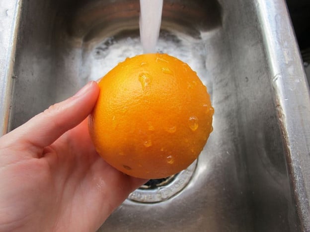 Washing oranges in the sink.