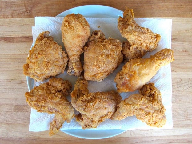 Fried chicken draining on paper towels.
