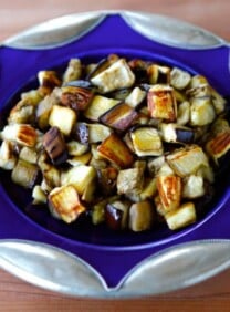 Purple plate with roasted eggplant slices on the countertop