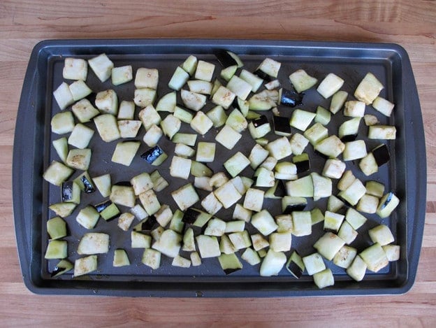 Eggplant cubes on a baking sheet.