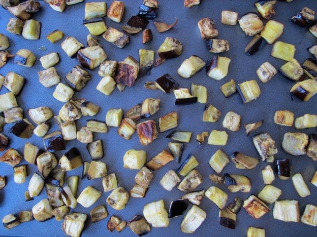 Roasted eggplant cubes on a baking sheet.