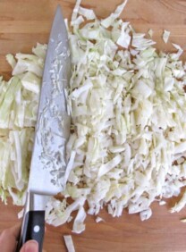 Chopped cabbage being prepared on cutting board