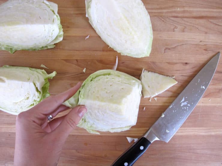 A person skillfully chopping cabbage on a cutting board, creating finely chopped cabbage