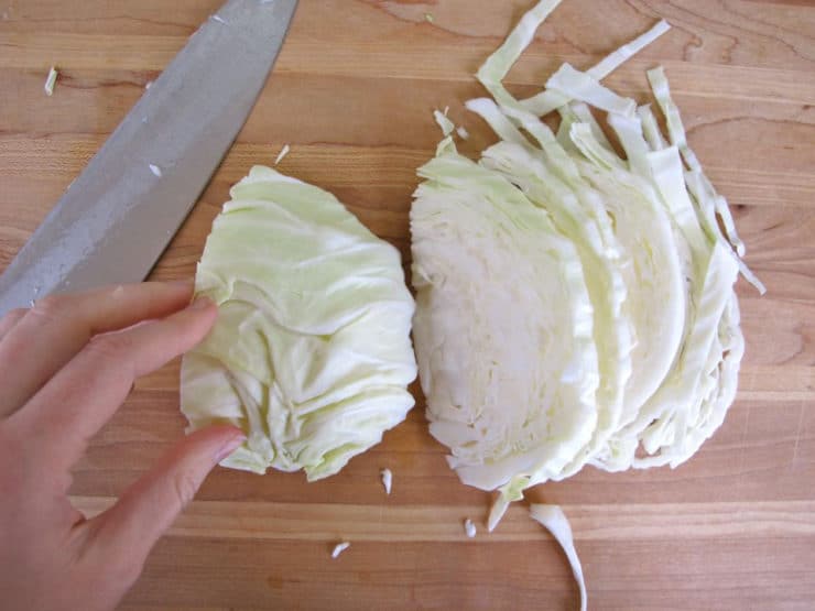 Person chopping cabbage on cutting board
