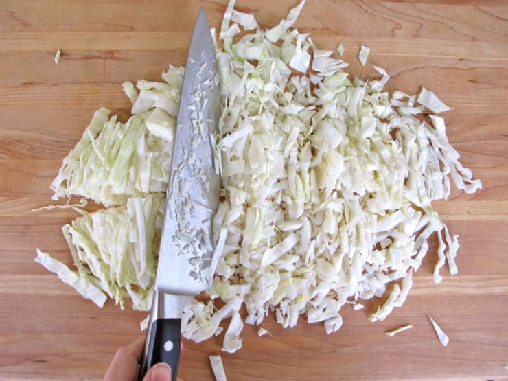 Chopped cabbage being prepared on cutting board