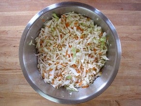 Shredded cabbage and carrots in a mixing bowl.