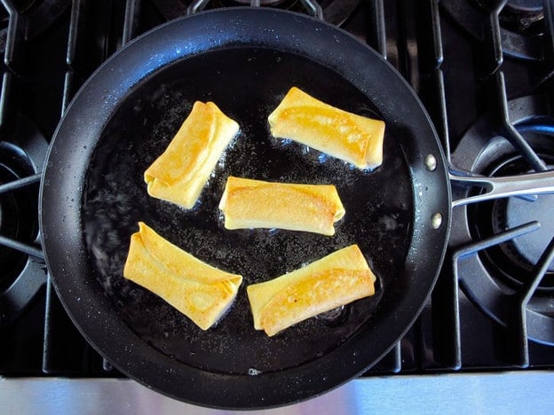 Frying blintzes in a skillet.