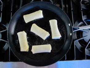 Frying blintzes in a skillet.