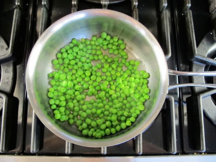 Frozen peas in a saucepan.