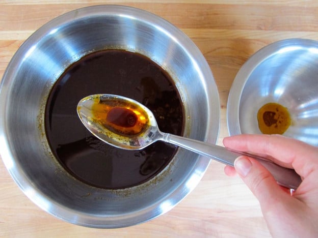 Skimming fat off a bowl of barbecue sauce.