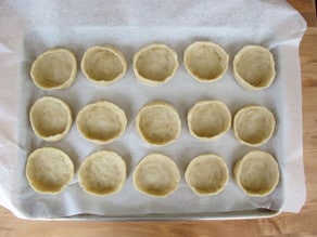 Shaping dough into cups on a parchment lined sheet.
