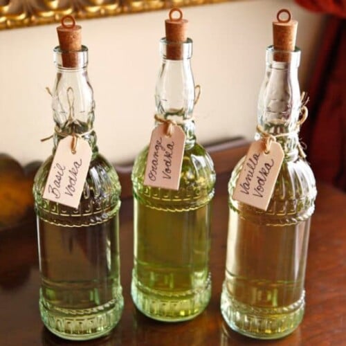 Three bottles of wine with flavor labels hanged on the bottle necks.