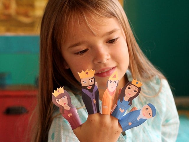 Small playing with Purim Finger Puppets on her fingers