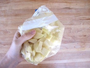 Diced potatoes and oil in a zippered bag.
