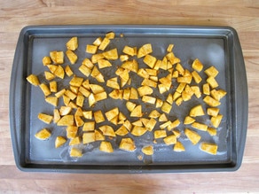 Diced potatoes spread on a baking sheet.