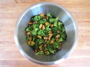 Cooked broccoli and potatoes in a mixing bowl.