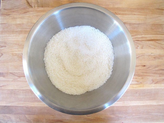 Stirring coconut and starches in a bowl.