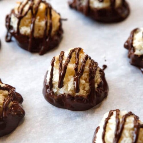 Dark chocolate dipped coconut macaroons on a white plate