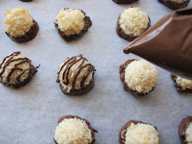 Drizzling chocolate over coconut macaroons.