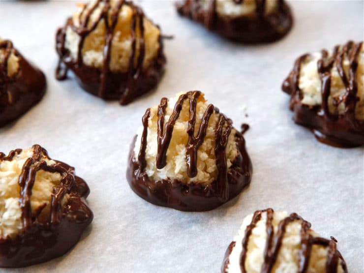 Dark chocolate dipped coconut macaroons on a white plate