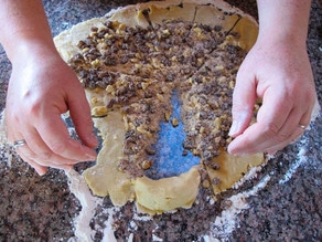Rolling dough wedges into rugelach shape.