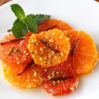 Orange and mint salad with pistachios served on a white plate