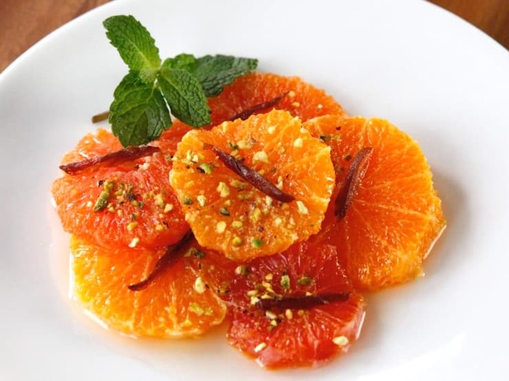 Orange and mint salad with pistachios served on a white plate