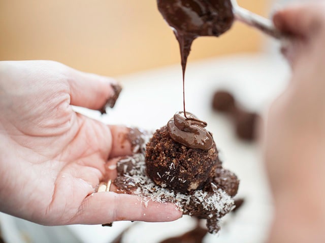 Drizzling chocolate over cake balls.