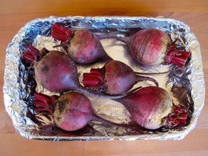 Cleaned beets in a foil lined baking dish.