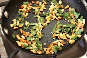 Roasting pine nuts in a skillet.