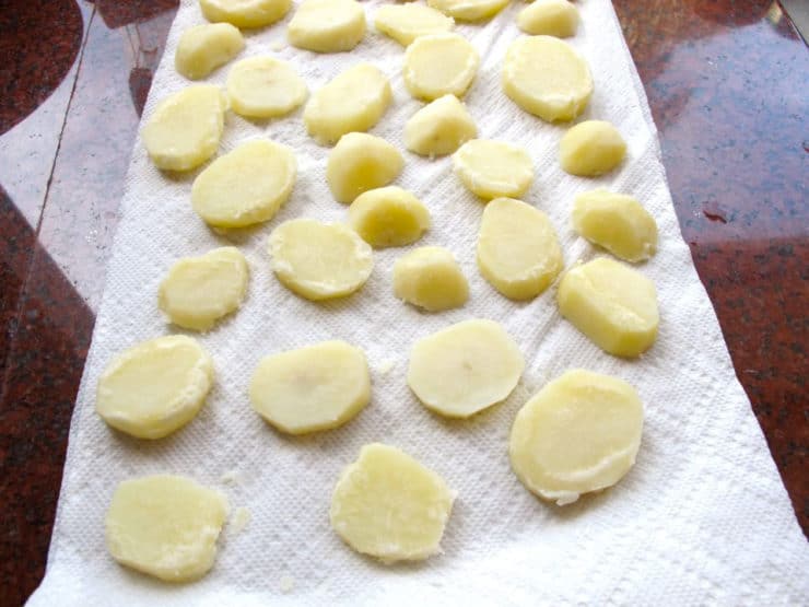 Cooked potatoes drying on paper towels.